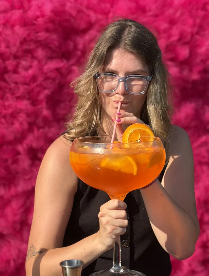 Barmanka serwuje koktajl przy różowym barze